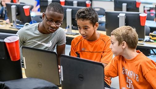 Students in a kids camps looking at a computer screen